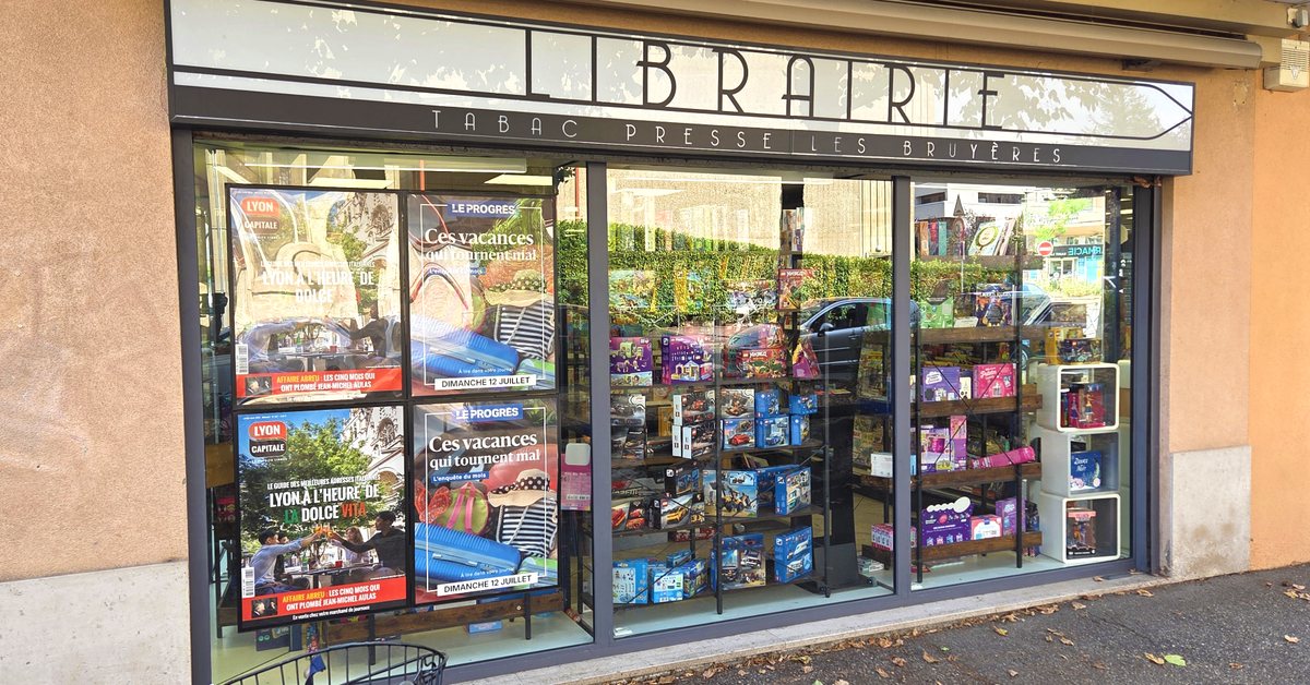 Devanture d’une librairie tabac-presse avec quatre affiches en vitrine